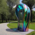 Photo of a iridescent friendly futuristic organically shaped telephone booth standing beside a path in a park in summer photo.jpeg